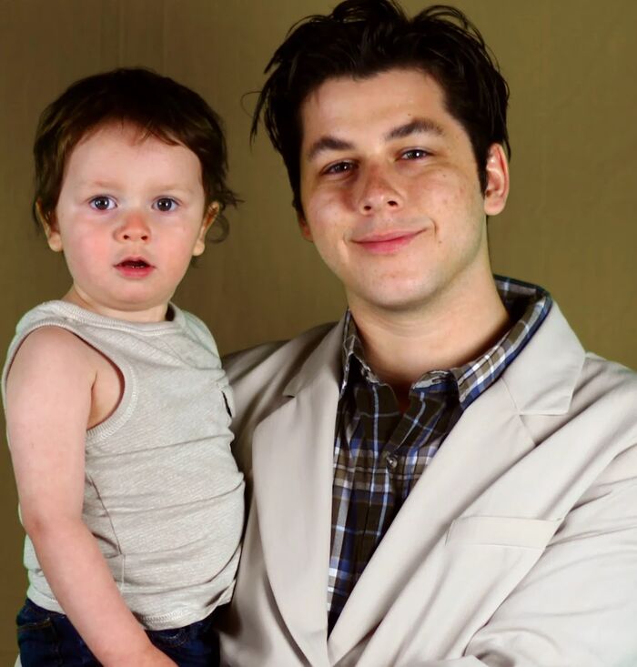 Young Cameron in a suit holding toddler Phoenix